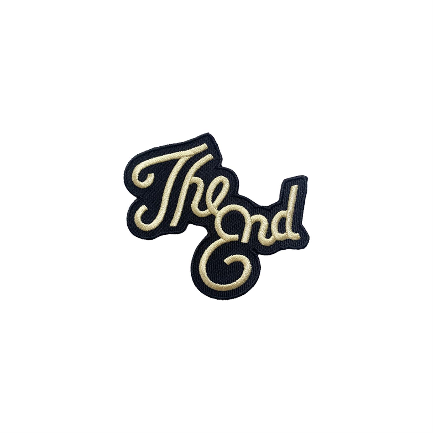 Ein eleganter Aufnäher mit der Aufschrift 'The End' in geschwungener Schrift auf einem schwarzen Hintergrund. Ideal für kreative Projekte oder zur Verzierung von Kleidung.